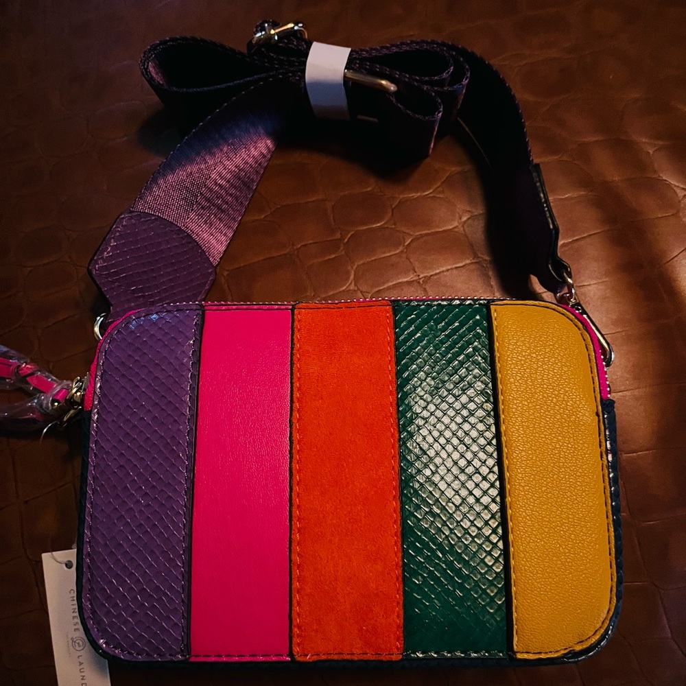 Multi-bright stripe crossbody with double zipper closure and adjustable strap.
